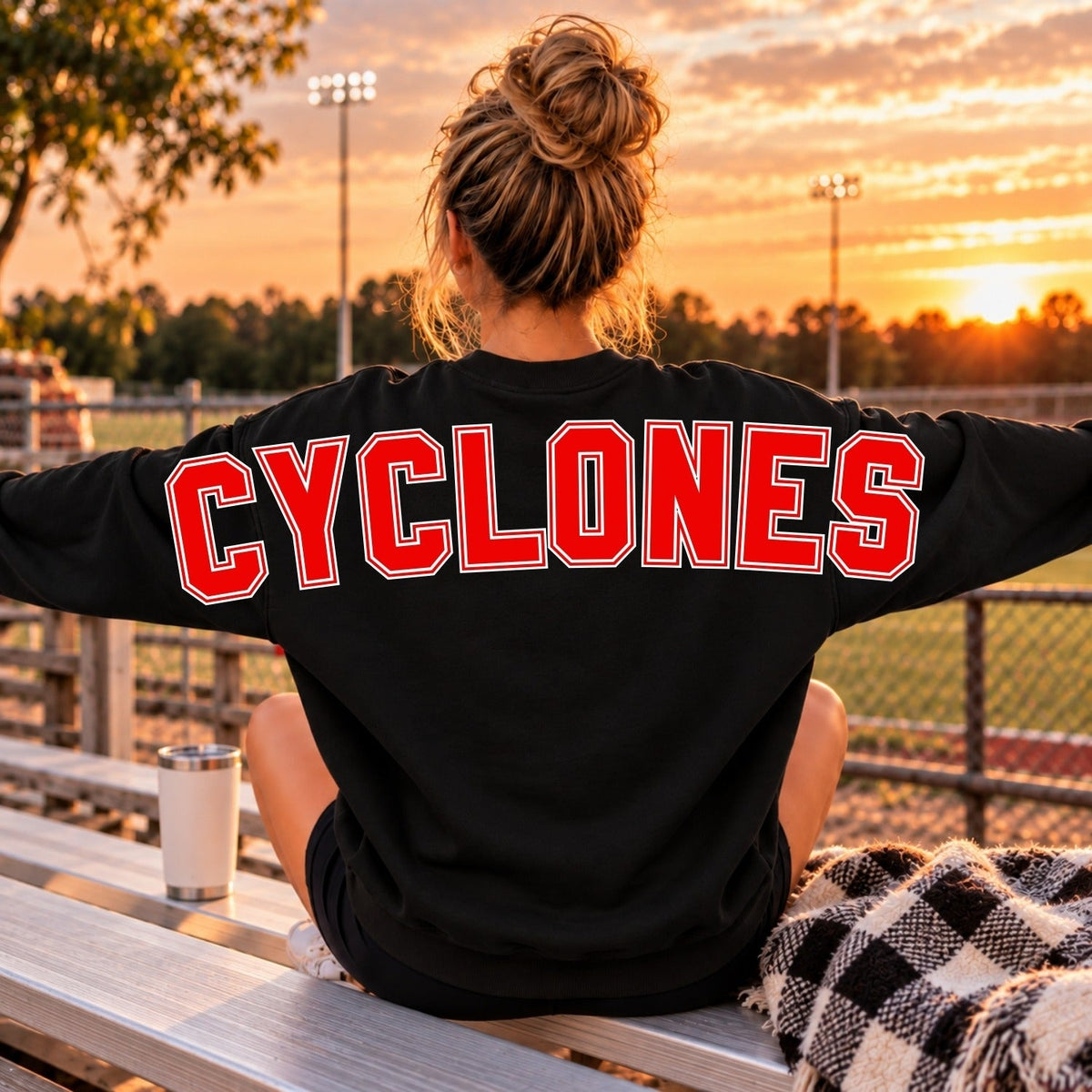 Red Cyclones lettering with white and black outline on black sweatshirt